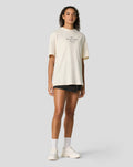 Front view of model wearing oversized egret tee with centered small Forever Faster graphic