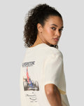 Profile view of a woman wearing an egret white oversized Silverstone T shirt with back graphic