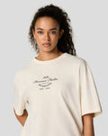 Side view of a woman wearing an egret oversized Silverstone T shirt showing the back print