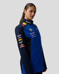 Front angled view of model wearing blue navy Teamline Soft Shell Jacket with multiple sponsor logos on the chest and collar.