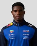 Front view of a male model in the Oracle Red Bull Racing Teamline Soft Shell Jacket in night sky blue with navy panels.