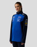 Model wearing Oracle Red Bull Racing Teamline Soft Shell Jacket in Night Sky blue with logos on chest and sleeves.