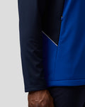 Close-up of the jacket side panel with piping detail in navy and blue.