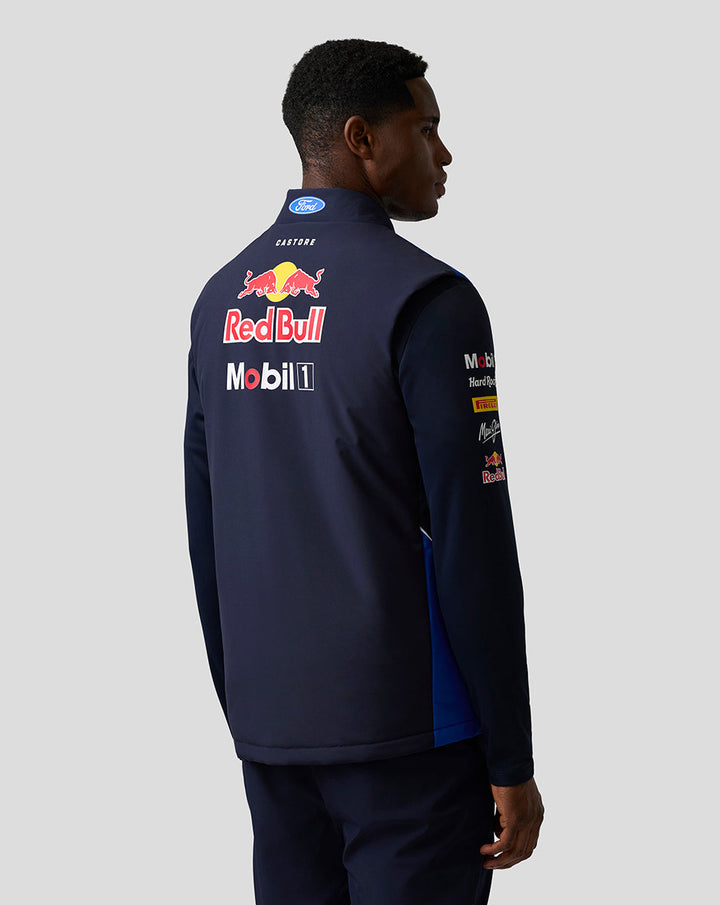 Back view of male model wearing navy Teamline Gilet with large Red Bull and sponsor logos on the back
