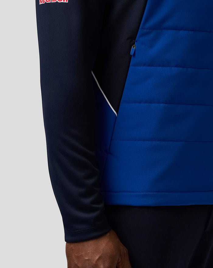 Side close up of the Teamline Gilet in Night Sky blue with zip pocket and branding at the front hem.