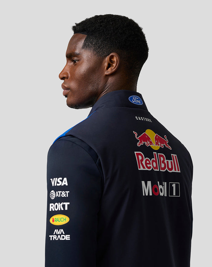 Back view of a male model wearing the Oracle Red Bull Racing Teamline Gilet in night sky blue with a large Red Bull logo on the back