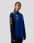 Female model wearing Oracle Red Bull Racing quarter zip midlayer in night sky blue with navy sleeves and sponsor logos on the chest.