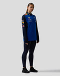 Female model wearing night sky blue Oracle Red Bull Racing Teamline quarter zip midlayer front view with sponsor logos on chest and sleeves