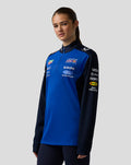 Model wearing Oracle Red Bull Racing Teamline Quarter Zip Midlayer in Night Sky blue with chest and sleeve logos.