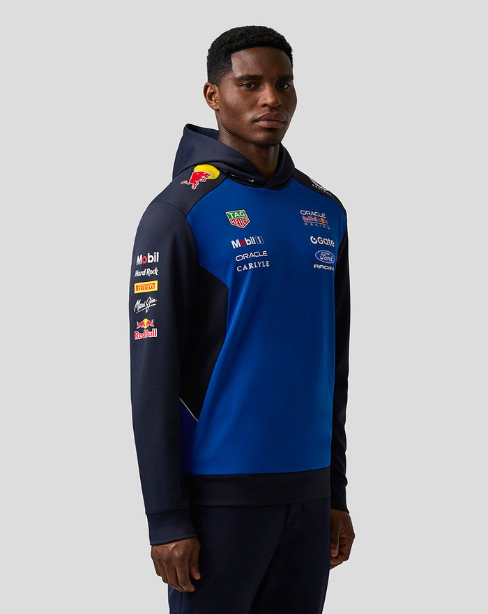 Male model wearing Oracle Red Bull Racing Teamline Overhead Hoodie in night sky blue with sponsor logos