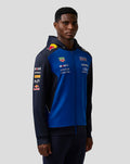 Male model wearing blue and navy Teamline full zip hoodie with hood and sponsor logos on the chest and sleeve