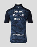 Back view of navy night sky polo with large Red Bull and Mobil 1 logos and HYPEBEAST branding on camouflage.