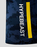 Close up of Oracle Red Bull Racing x Hypebeast Pro Team Kit Track Polo Night Sky showing digital camouflage fabric and a vertical white Hypebeast logo with a yellow stripe.