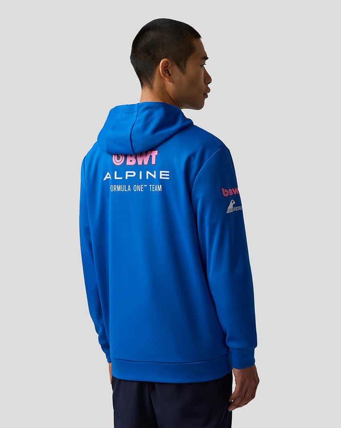 Back view of blue BWT Alpine hoodie on a model showing large Alpine branding on the back