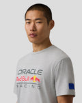 Male model wearing Oracle Red Bull Racing grey marl T shirt with a large chest logo and a blue badge on the left sleeve.