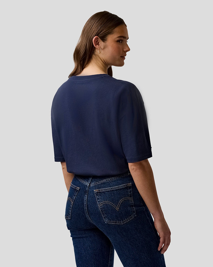 Back view of a person wearing a navy Oracle Red Bull Racing T shirt paired with jeans