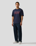 Man wearing Night Sky navy Oracle Red Bull Racing T-shirt with large front logo and left sleeve badge.