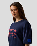 Woman in navy Oracle Red Bull Racing relaxed fit logo T-shirt with large chest print and blue sleeve badge.