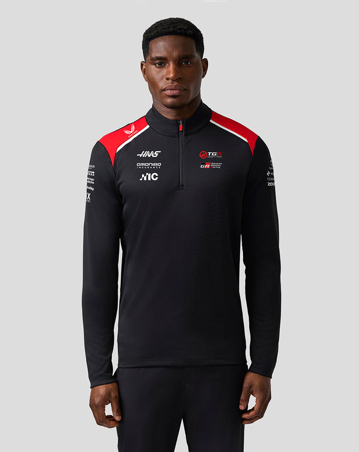 Close up of Official Haas Team Quarter Zip Midlayer showing front sponsor logos and red shoulder panel on black fabric