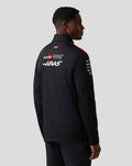 Back view of a male model in Haas Team soft shell jacket showing large GR and Haas logos on the back.