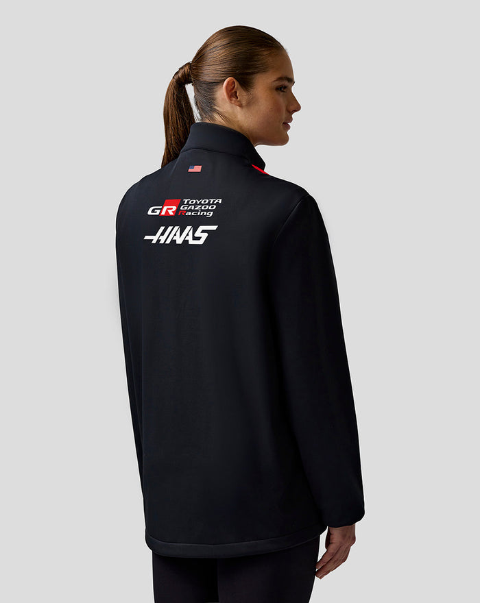Back view of Haas Team Unisex Soft Shell Jacket with Haas and Toyota Gazoo Racing branding and a small flag.