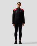 Front view of Haas Team Unisex Soft Shell Jacket on a female model with red shoulder panels and full front zipper.