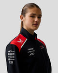 Female model wearing Haas Team Soft Shell Jacket in black with red shoulder panels.