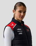 Female model wearing Official Haas Team Gilet in black with red shoulder panels and branding.