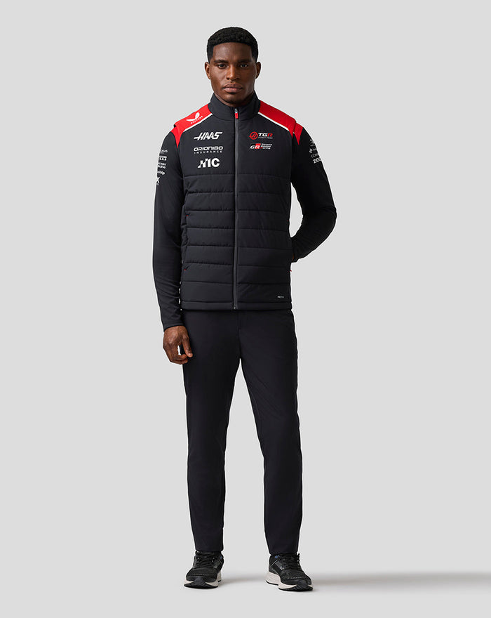 Man modeling the Official Haas Team Unisex Gilet with zip front red shoulder accents and sponsor logos on the chest