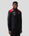 Male model wearing Haas Team Gilet with black quilted front and red shoulder panels with sponsor logos.