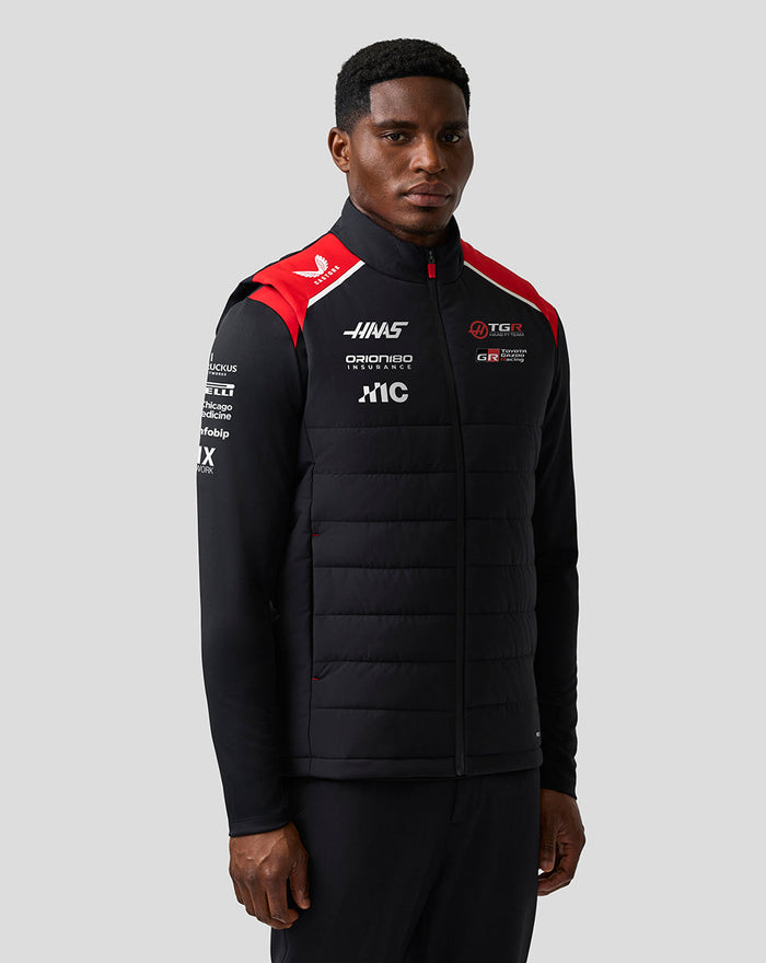 Male model wearing Haas Team Gilet with black quilted front and red shoulder panels with sponsor logos.