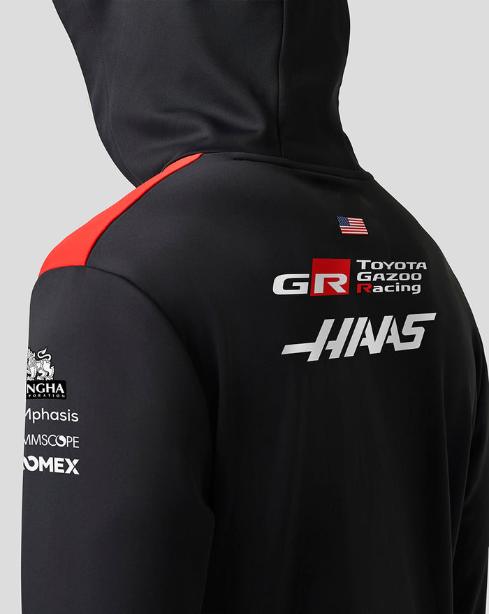 Back view of a black Haas Team pullover hoodie showing red shoulder panel and sponsor logos