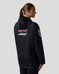 Profile view of a person in a black Haas Team hoodie with red shoulder panels and sponsor logos on the sleeve.