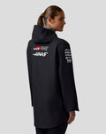 Rear view of black hooded Haas Team water-resistant jacket with red shoulder panels.