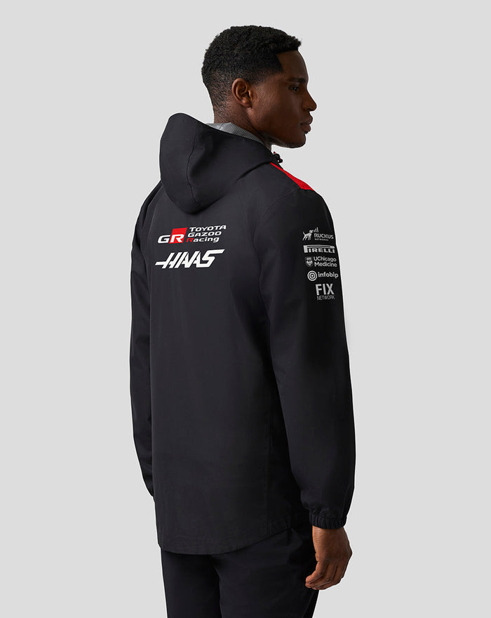 Back view of black hooded Haas Team water-resistant jacket with Haas and Toyota Gazoo Racing branding.