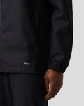 Official Haas Team unisex water resistant jacket detail showing PROTEK logo at the front lower hem