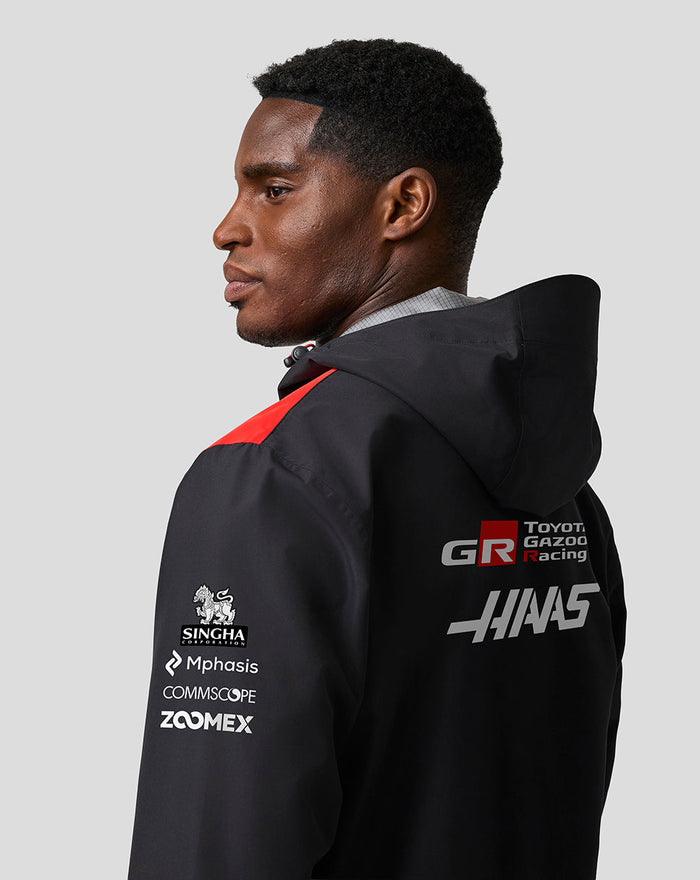 Back view of black Haas Team water resistant jacket showing hood and large Haas branding on the back