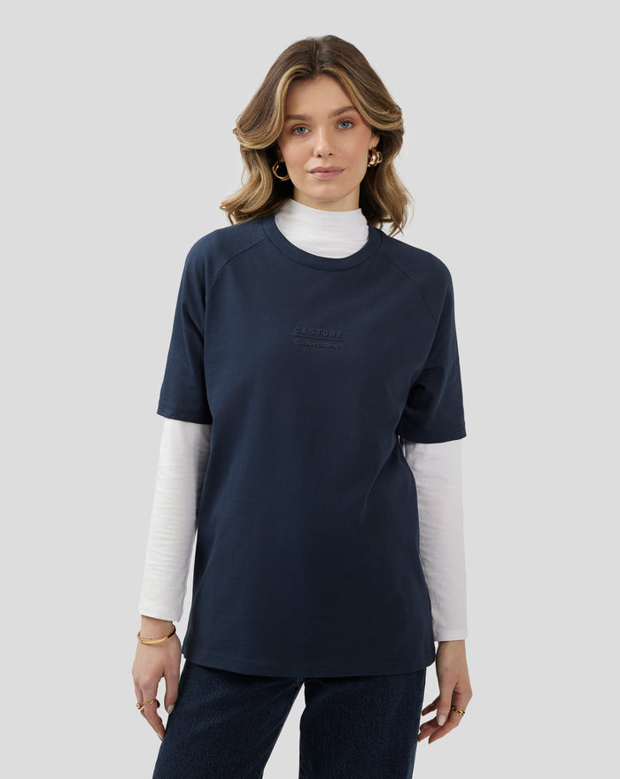 Model wearing navy Silverstone x Castore raglan short sleeve T-shirt with embossed chest logo and back neck emblem.