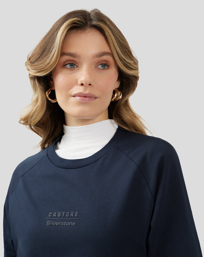 Close up of model wearing navy raglan short sleeve T-shirt with embossed chest logo.