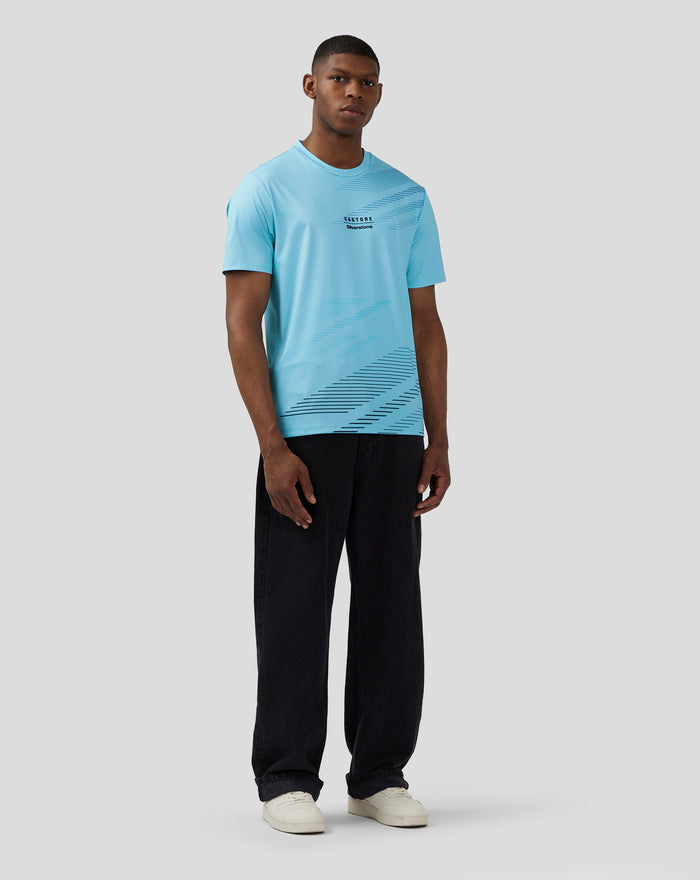 Full upper body of a man in Cabana Blue Silverstone x Castore sublimated short sleeve T-shirt with diagonal stripe print