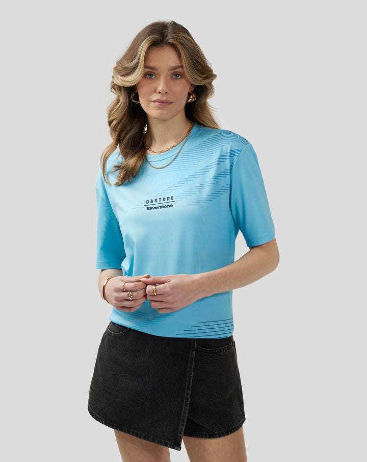 Front view of a woman wearing a light blue Cabana Blue short sleeve T shirt with diagonal graphic and accessories