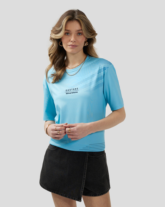 Front view of a woman wearing a light blue Cabana Blue short sleeve T shirt with diagonal graphic and accessories
