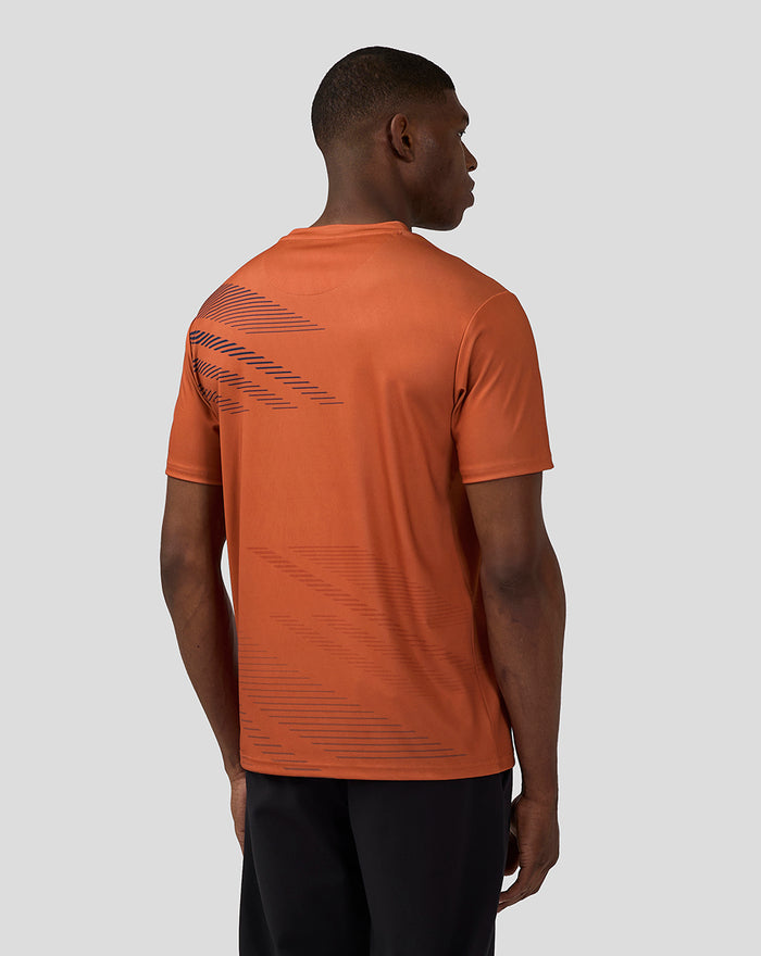 Back view of the orange rust shirt showing a diagonal navy graphic across the upper back.