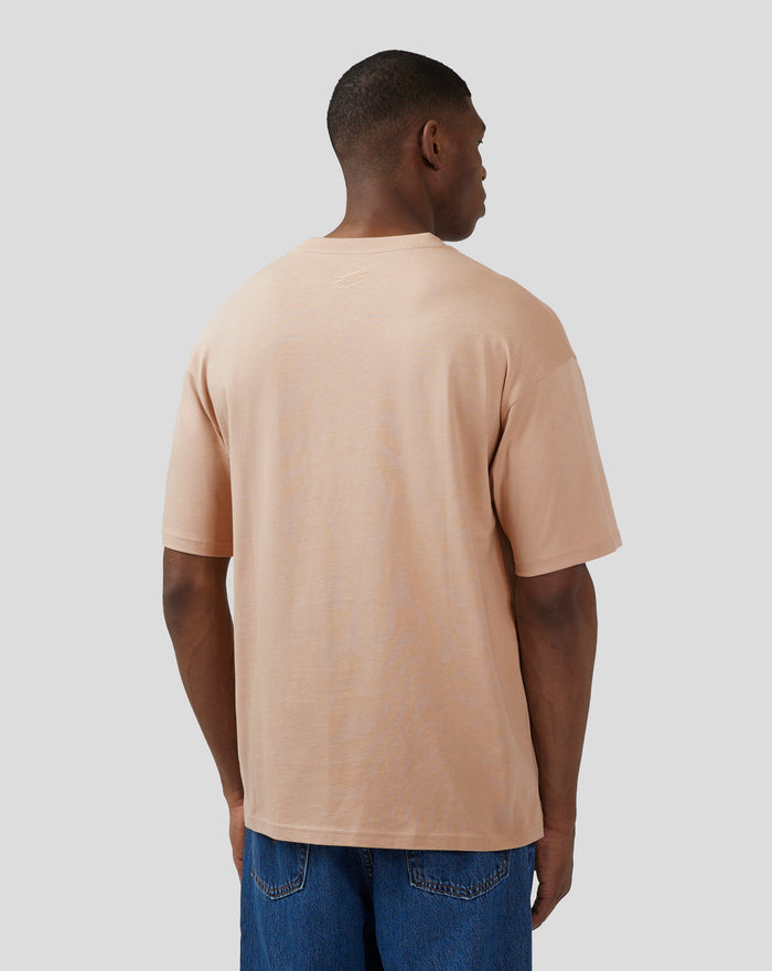 Back view of a model wearing a doeskin oversized Silverstone x Castore short sleeve tee with a subtle back neck logo