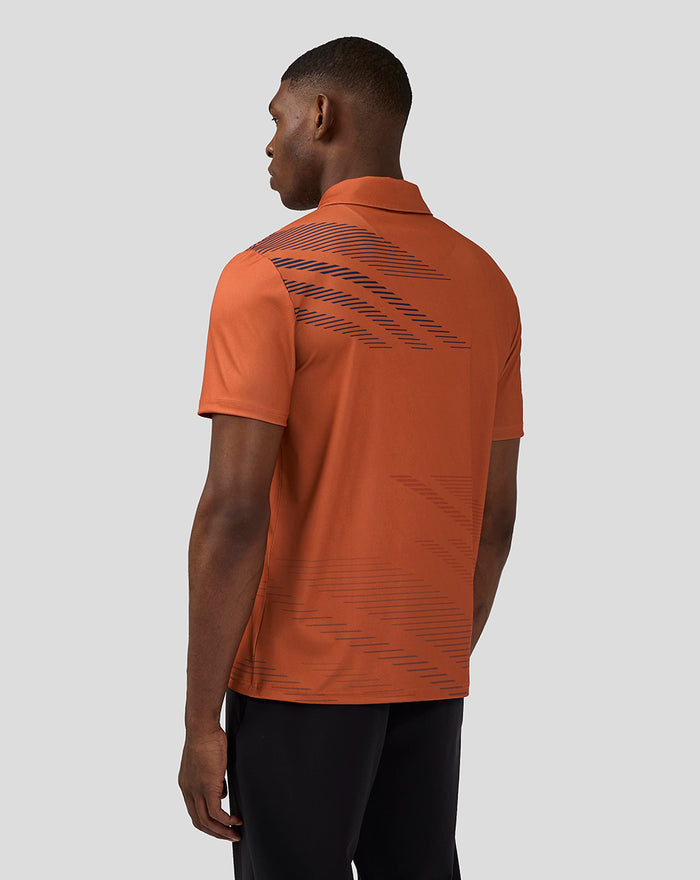 Back view of orange rust polo showing navy diagonal line pattern across the upper back