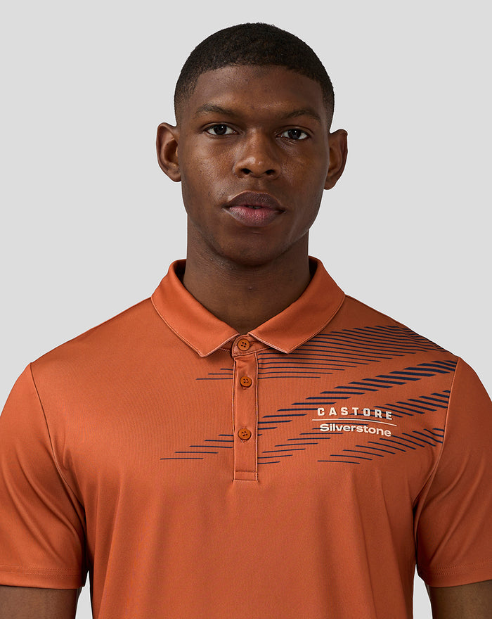 Front view of a man wearing orange rust sublimated short sleeve polo with navy diagonal lines on the chest.