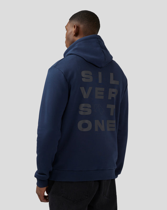Three quarter back view of a woman in a navy hoodie with bold vertical Silverstone lettering on the back
