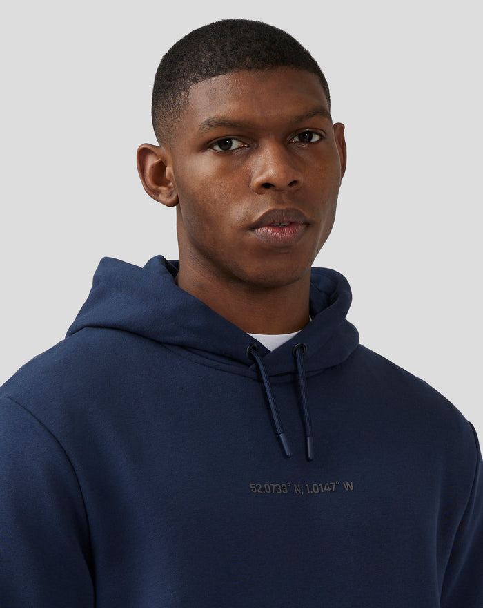 Front-left close up of a model wearing a navy loopback fleece hoodie with hood and drawstrings