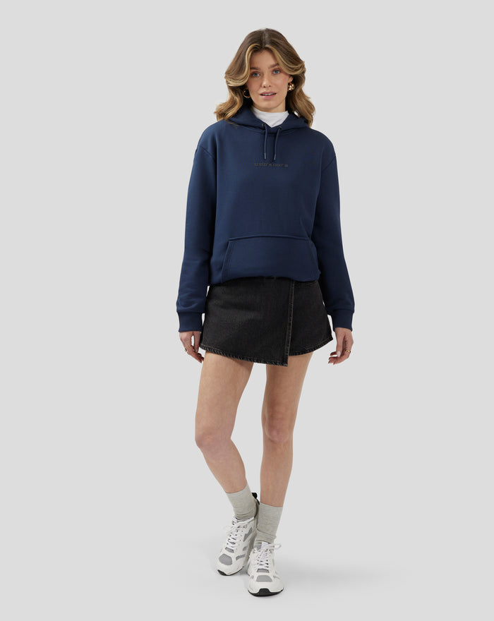Model wearing a dark blue Silverstone Core Graphic Hoodie paired with a black denim skirt