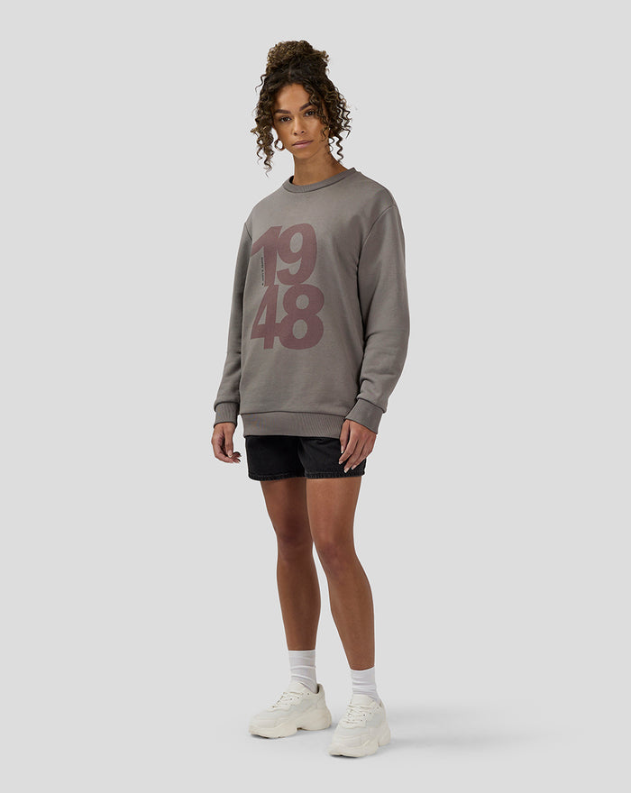 Model wearing charcoal Silverstone Core Sweatshirt with 1948 graphic paired with black shorts
